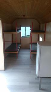 a room with bunk beds and a refrigerator in it at Treene Camp Horn in Esperstoft