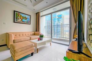a living room with a couch and a large window at Central Apartments - Vinhomes Central Park, Landmark 81 Area & Ice Skating Rink in Ho Chi Minh City