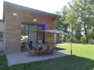 a patio with a table and chairs and an umbrella at Gîte Veauchette, 3 pièces, 4 personnes - FR-1-496-78 in Veauchette