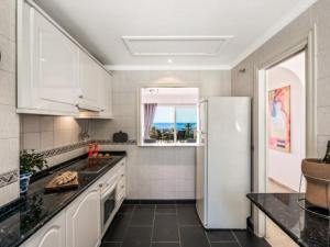 cocina con nevera blanca y ventana en JAZMIN MIRAFLORES SENSATIONAL VIEW! POOL, TERRACE, WiFi en La Cala de Mijas