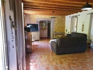 a living room with a couch and a tv at Maison de Vacances in Tursac