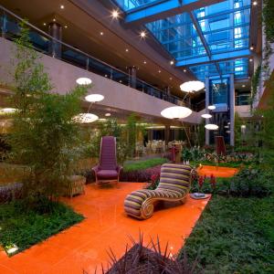 a lobby with chairs and plants in a building at Iberik Santo Domingo Plaza Hotel in Oviedo