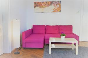 a purple couch in a living room with a table at City-Apartments Langegger in Vienna