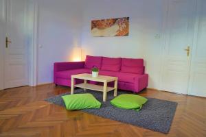 a living room with a purple couch and a table at City-Apartments Langegger in Vienna