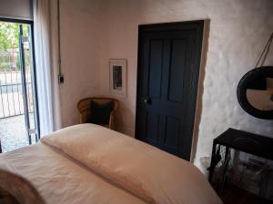 a bedroom with a bed and a door to a balcony at House of Pinardt in Robertson