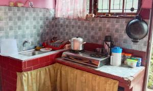a small kitchen with a stove and a sink at Malin's Homestay in Bukittinggi