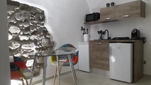 eine Küche mit einem Tisch und einer Steinmauer in der Unterkunft C'era una volta (suite) in Isolabona