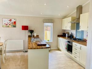 a kitchen with white cabinets and a counter top at Hollicarrs - Wildflower Lodge in York