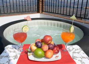 un plato de fruta y dos vasos de zumo en una mesa en Casa Jose Comares -Beautiful village house- JACUZZI INCLUDED-views-BBQ-aircon-WIFI, en Comares