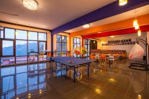 a room with tables and chairs in a restaurant at goSTOPS Mussoorie, Picture Palace in Mussoorie