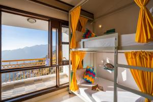 a room with bunk beds and a large window at goSTOPS Mussoorie, Picture Palace in Mussoorie