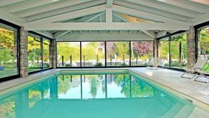 an indoor swimming pool with a view of the trees at Park Residence Il Gabbiano in Moniga