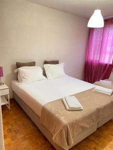 リスボンにあるDuplex Próximo do Aeroporto Lisboaのベッドルーム(ピンクの窓、大きな白いベッド付)