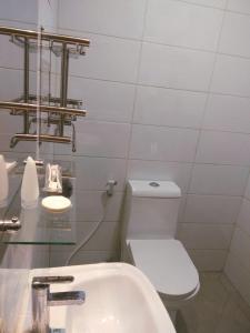 La salle de bains blanche est pourvue de toilettes et d'un lavabo. dans l'établissement HOTEL LENGKONG 2, à Bandung