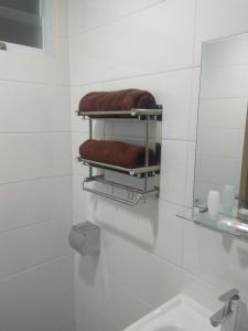 a bathroom with a mirror and a towel rack at HOTEL LENGKONG 2 in Bandung