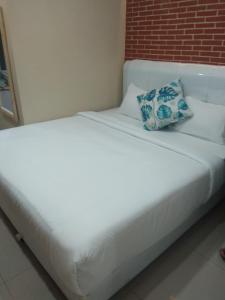 a white bed with a pillow on top of it at HOTEL LENGKONG 2 in Bandung
