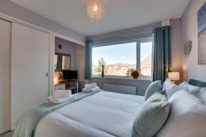a bedroom with a large white bed with a large window at Abbey View Bagdale in the Centre of Whitby in Whitby
