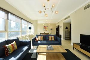 sala de estar con sofá azul y mesa en 2-BR Marina View Retreat at Marina Quays - DSY, en Dubái