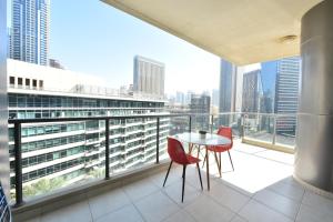balcón con mesa, sillas y vistas a la ciudad en 2-BR Marina View Retreat at Marina Quays - DSY, en Dubái