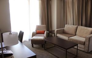 a living room with a couch and chairs and a table at Rydges Wellington in Wellington
