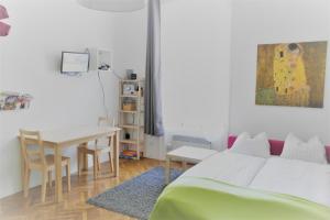 sypialnia z łóżkiem, biurkiem i stołem w obiekcie City-Apartments Langegger w Wiedniu