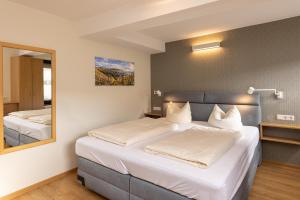 ein Schlafzimmer mit einem großen Bett und einem Spiegel in der Unterkunft Hotel-Restaurant Ehses in Zeltingen-Rachtig