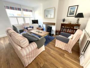 a living room with two couches and a table at Pebble Beach in Deal