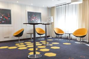 a room with yellow chairs and a table and a rug at Park Inn by Radisson Hotel Astana in Astana