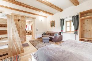 a bedroom with a bed and a couch at Ferienhaus Spitzenhof - Urlaub am Bauernhof in Mooslandl