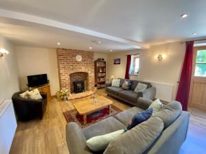 a living room with a couch and a fireplace at The Teddy House in Ottery Saint Mary
