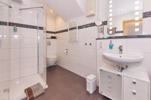 een witte badkamer met een wastafel en een douche bij Hotel-Restaurant Ehses in Zeltingen-Rachtig