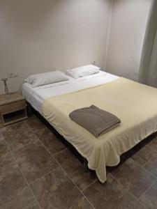 twee bedden in een slaapkamer met een handdoek op het bed bij Gonil in Conil de la Frontera