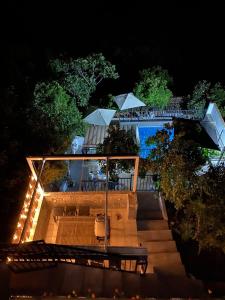 eine Terrasse mit einem Tisch und Sonnenschirmen in der Nacht in der Unterkunft Stunning 4-Bed House in Benamahoma in Benamahoma