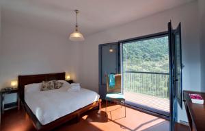 sypialnia z łóżkiem i dużym oknem w obiekcie Stunning home Benamahoma 4 Bed - Sierra Grazalema w mieście Benamahoma