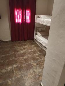 een kamer met een rood gordijn en een stapelbed bij Gonil in Conil de la Frontera