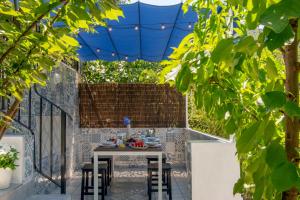 stół i krzesła na patio pod niebieskim parasolem w obiekcie Stunning home Benamahoma 4 Bed - Sierra Grazalema w mieście Benamahoma