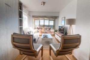 a living room with two chairs and a table at Moonkey - Estudio Las Lanzas in El Campello