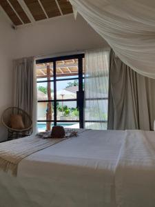 a bedroom with a bed and a view of a pool at Wilson's Retreat in Gili Trawangan