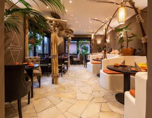 a restaurant with tables and chairs and a lobby at Hotel Luina Beach in Büsum