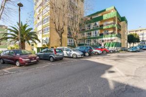 a row of cars parked in a parking lot next to a building at Isabel Dream III, 400m from the train in Rinchoa