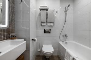 een witte badkamer met een toilet en een bad bij Апарт-отель YE'S Mitino in Moskou