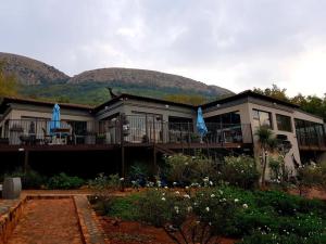 una casa con sombrillas azules delante de ella en Magalies Mountain Lodge and Spa, en Hartbeespoort