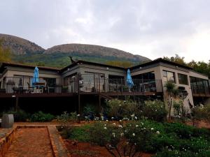 a house with blue umbrellas in front of it at Magalies Mountain Lodge and Spa in Hartbeespoort