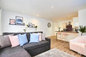 a living room with a gray couch and a kitchen at Stunning 2 bed Apartment - Central Location in Leeds