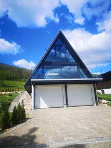 a house with two garage doors and a roof at Ferienhaus Fynnhütte in Schwarzenborn