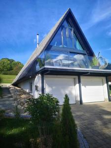 una casa con techo azul y garaje en Ferienhaus Fynnhütte, en Schwarzenborn