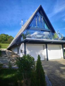 a house with a blue roof and a garage at Ferienhaus Fynnhütte in Schwarzenborn