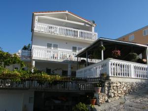 a white house with a balcony with plants on it at Apartments Zdenka in Marina