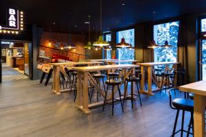 un bar con mesas de madera y sillas en un restaurante en RockyPop Flaine Hotel & Spa, en Flaine