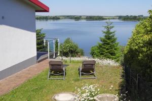 twee stoelen op een gazon met uitzicht op een meer bij Holiday home Seeblick, Fürstenwerder in Fürstenwerder